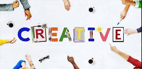 Das Wort "Creative" auf einem Tisch mit Menschen drumherum creative-gestalten-osnabrueck-mevelo