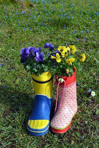 Zwei Stiefel auf einer Wiese. In den Stiefel wachsen Blumen. impulse-workshops-osnabrueck